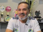 Homem de barba grisalha, natural da Bolívia, com troféus