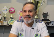 Homem de barba grisalha, natural da Bolívia, com troféus